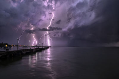 Panoramic view of lightning over sea against dramatic sky