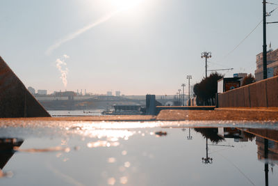 Surface level of puddle on street during sunny day