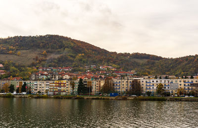 Townscape by river against sky in town