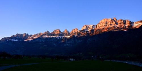 Scenic view of mountains against clear blue sky