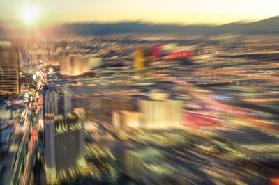 Defocused image of illuminated city against sky at night