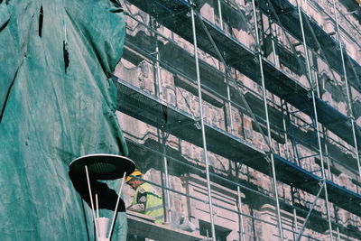 Low angle view of man working on building