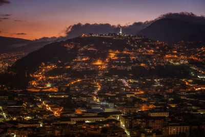 Aerial view of illuminated cityscape against sky at sunset