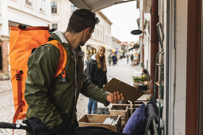 Man showing placard to woman while doing shopping at city