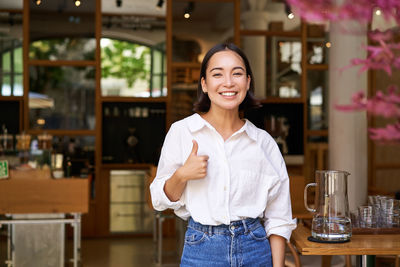 Portrait of young woman standing in store