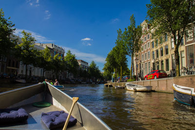 Boats moored in water against blue sky