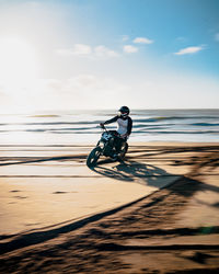 Man riding bicycle on water against sky