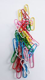 High angle view of colorful paper clips on white background