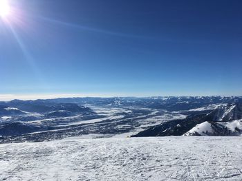 Scenic view of snowcapped mountains against clear blue sky