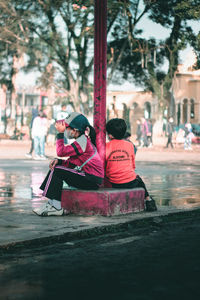 Rear view of couple sitting on boat in canal