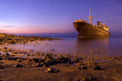 Ship in calm sea against blue sky