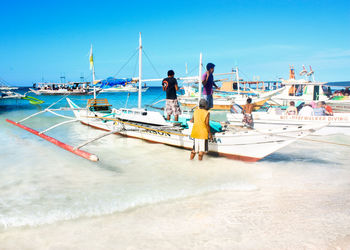 People on beach against blue sky