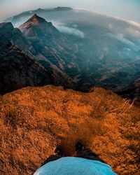 Low section of person standing on rock against mountains