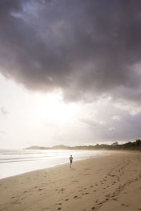 Man on shore at beach against sky