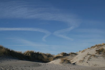 Scenic view of sand dunes against sky