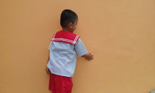 Boy standing against wall