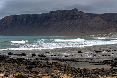 Scenic view of sea and mountains against sky