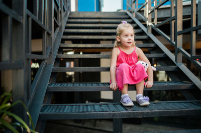 Portrait of young woman sitting on staircase