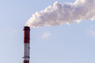 Low angle view of smoke stack against sky