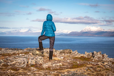 Rear view of person looking at sea against sky