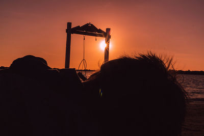 Silhouette people on beach against sky during sunset
