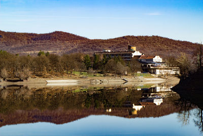 Scenic view of lake by buildings against sky