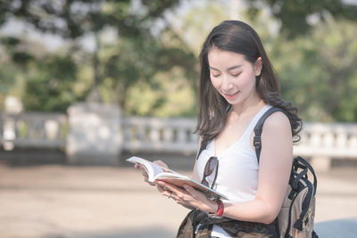 Young woman looking at camera while standing outdoors