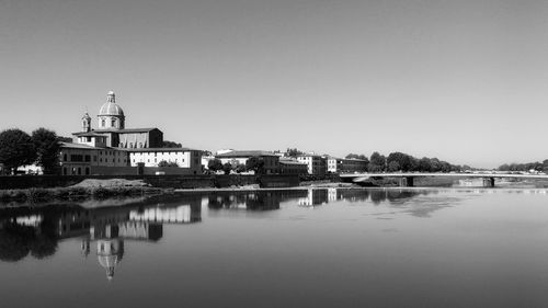 Reflection of dome and buildings on arno river against clear sky