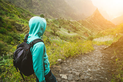 High angle view of man with backpack standing on mountain