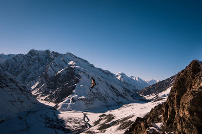 Scenic view of snowcapped mountains against clear blue sky