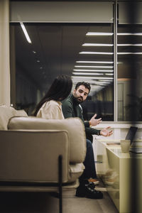 Businessman discussing strategy with female colleague while working late at work place