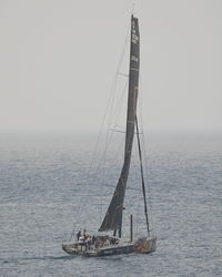 Sailboat sailing on sea against sky