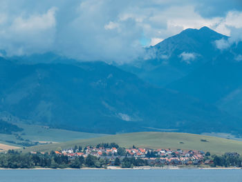 Aerial view of townscape by mountain against sky