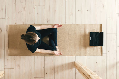 Woman sitting on wooden floor