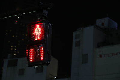 Low angle view of illuminated road sign at night