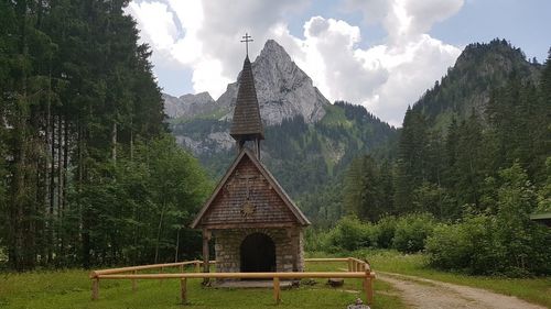 Gazebo amidst trees and buildings against sky