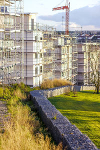 Construction site by buildings in city against sky