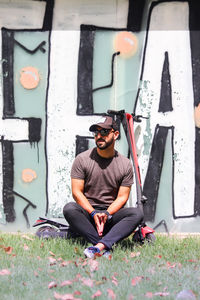 Portrait of young man sitting on plant