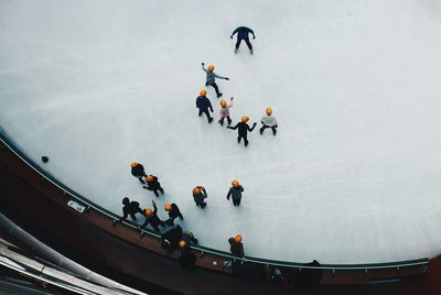 High angle view of people ice-skating on frozen landscape