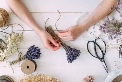 Hands of a florist woman at work. dry compositions of flowers and plants for the interior