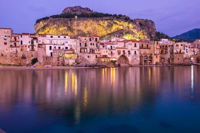 Reflection of buildings in lake at dusk