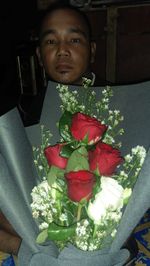 Portrait of man holding rose bouquet
