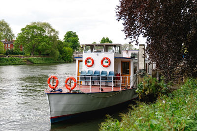 Boat moored in river against sky