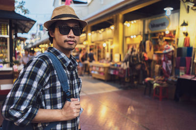 Portrait of young man wearing sunglasses standing in city