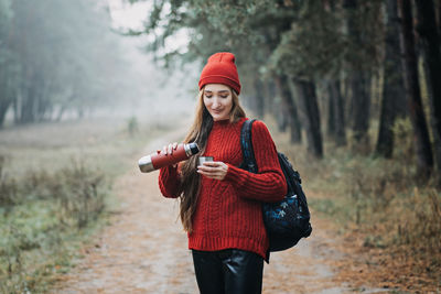 Sustainable tourism, responsible travel. young woman traveler with backpack holding tremors zero