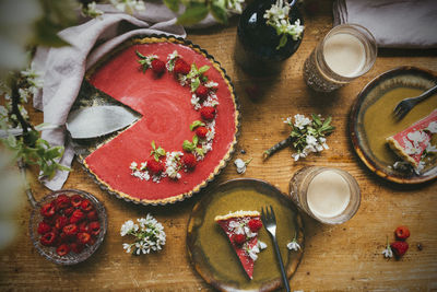 High angle view of raspberry cake and fresh raspberry fruits served on table with coffee