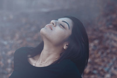 Beautiful woman with eyes closed relaxing on field