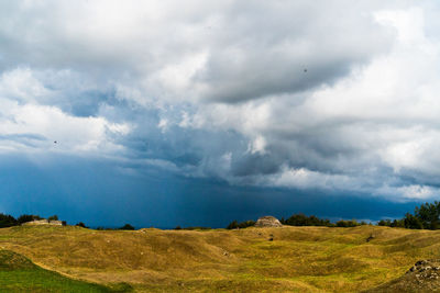 Scenic view of land with bomb craters against sky