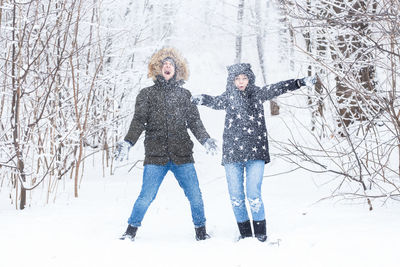 Full length of woman standing on snow covered tree