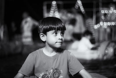 Boy looking away while sitting outdoors